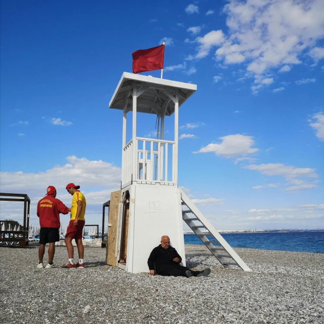 a man standing next to a life guard tower