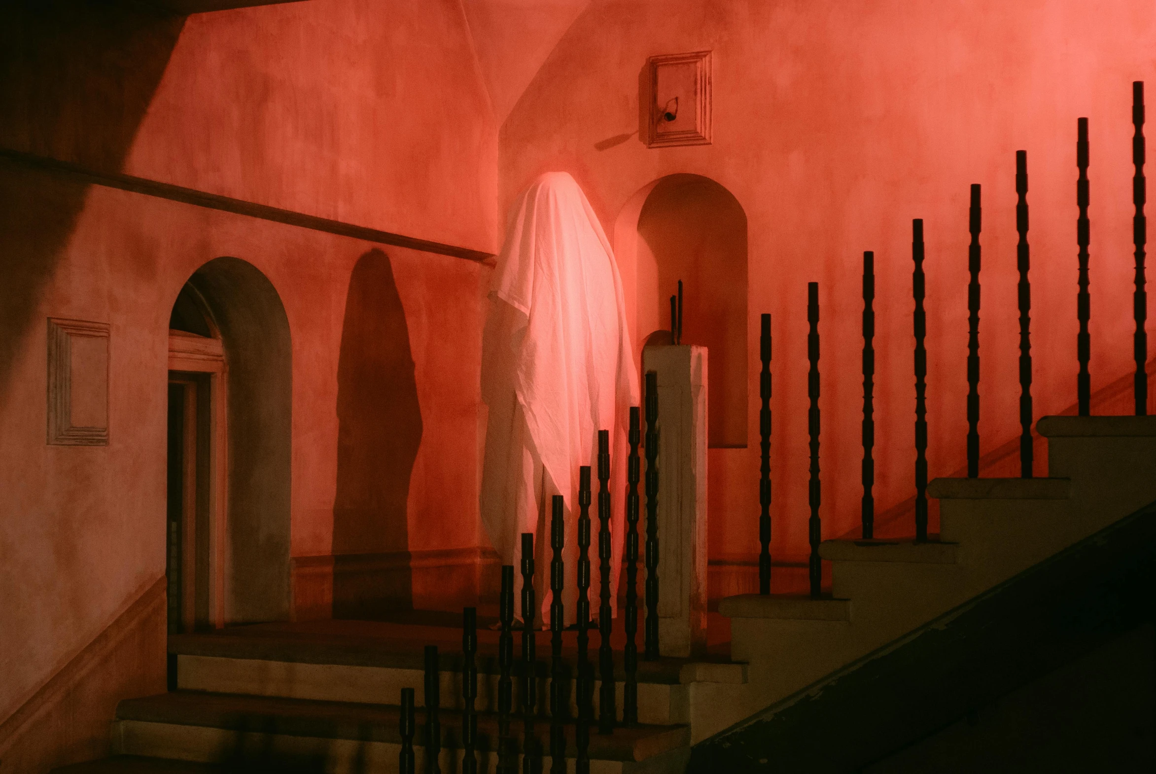 an artistic painting shows a staircase in a large red building