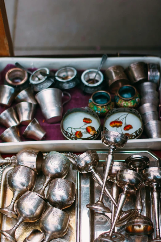 an old, metalware box full of silver ware