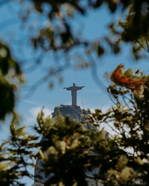 the statue on top of the mountain has a cross between it