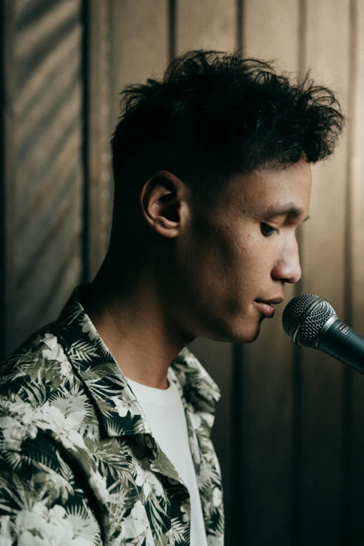 a young man in hawaiian shirt playing a music instrument