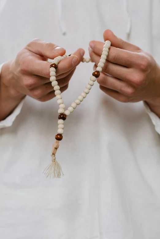 a man holding rosary beads that have been tied into the end of it