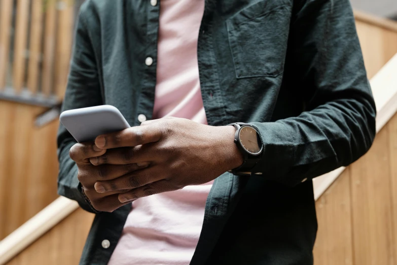 the man is typing his cellphone on his left hand