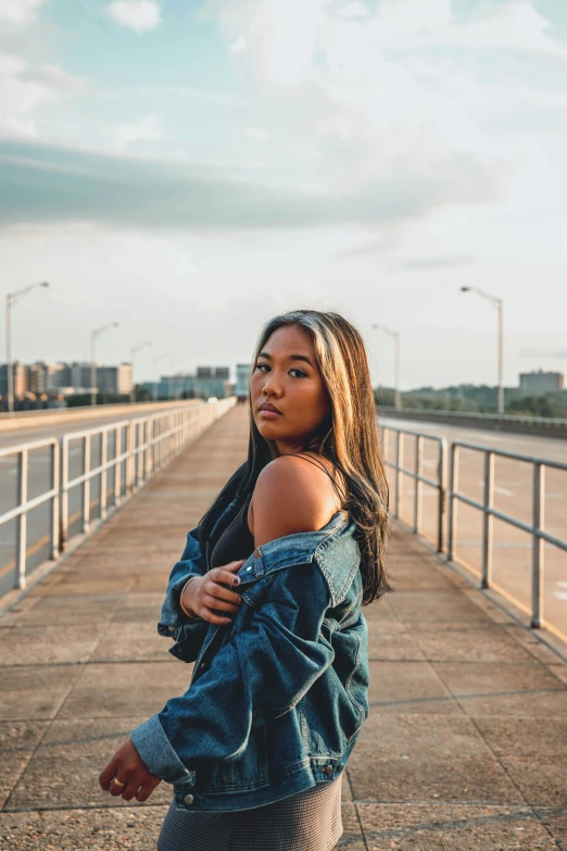 a young woman is leaning against her denim jacket