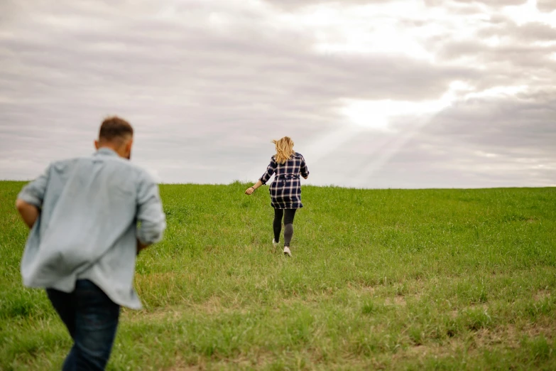 a person walking down a grass covered field