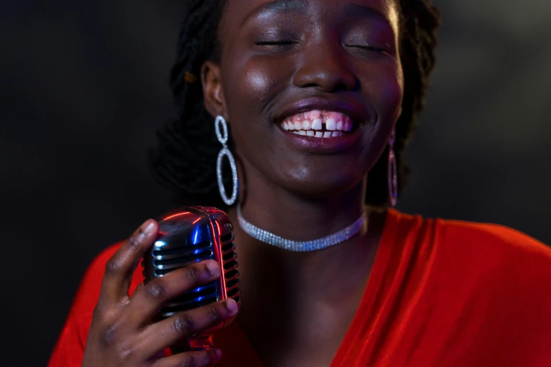 a smiling woman with her eyes closed holding a cell phone