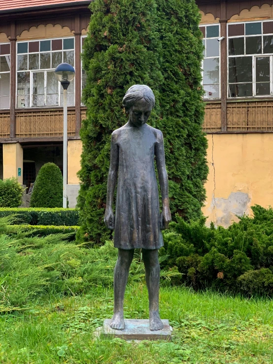 a statue of a woman standing in front of an old building
