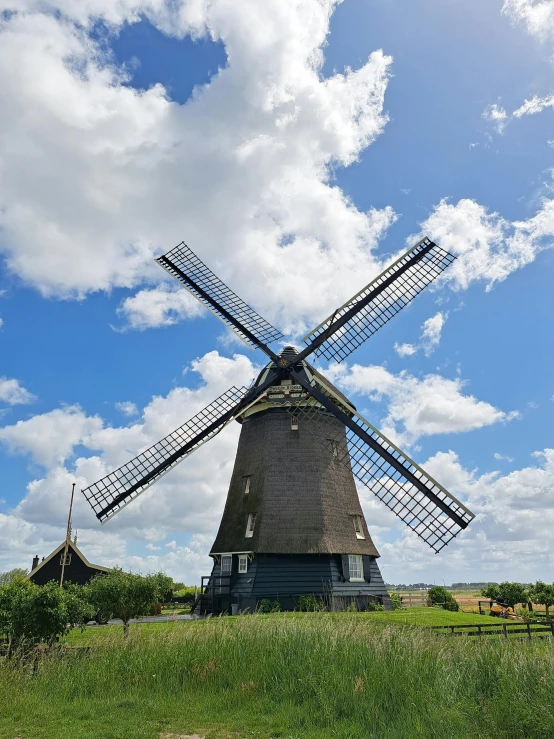 a very old windmill standing on top of a lush green hillside