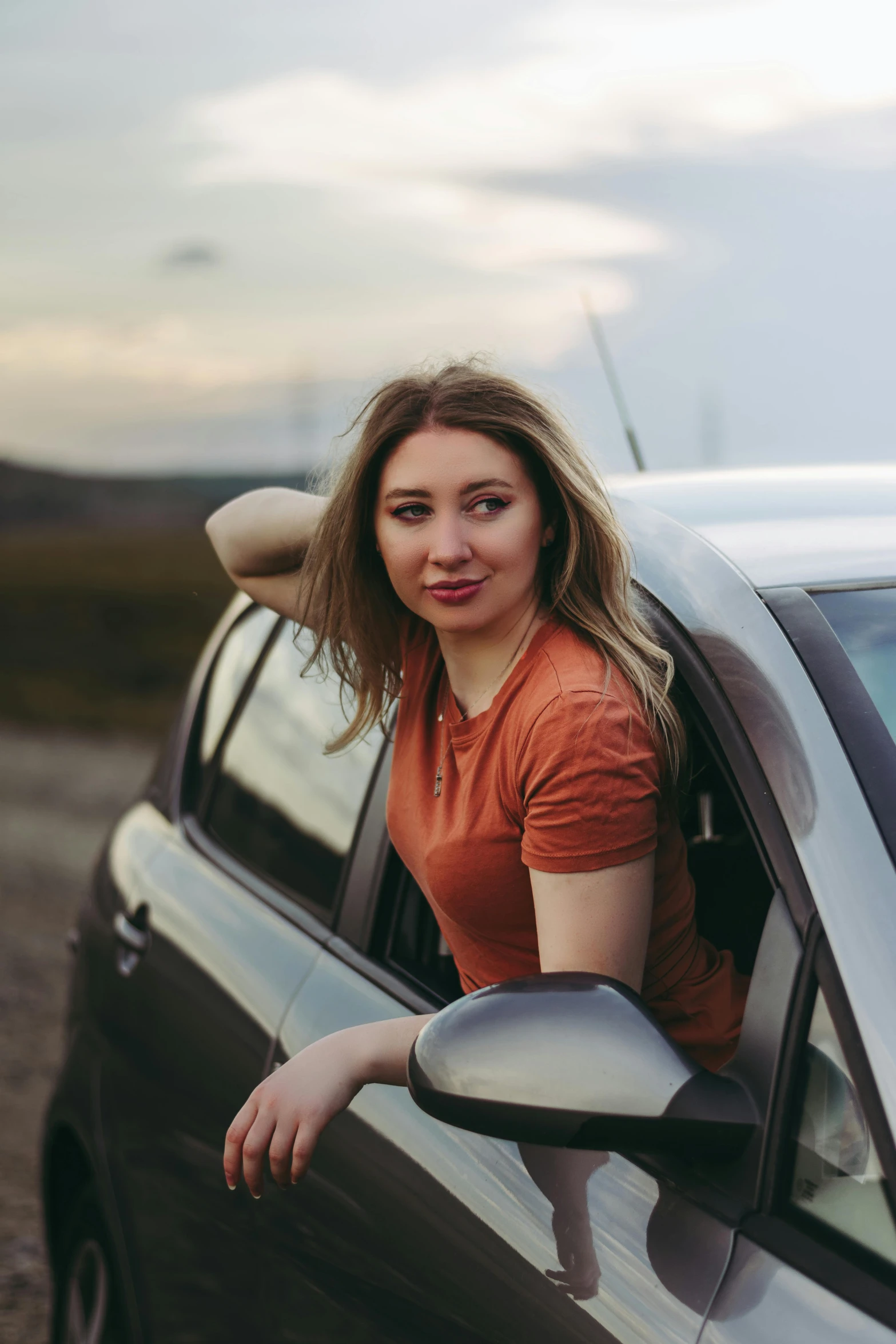 a woman leaning out the window of a parked car