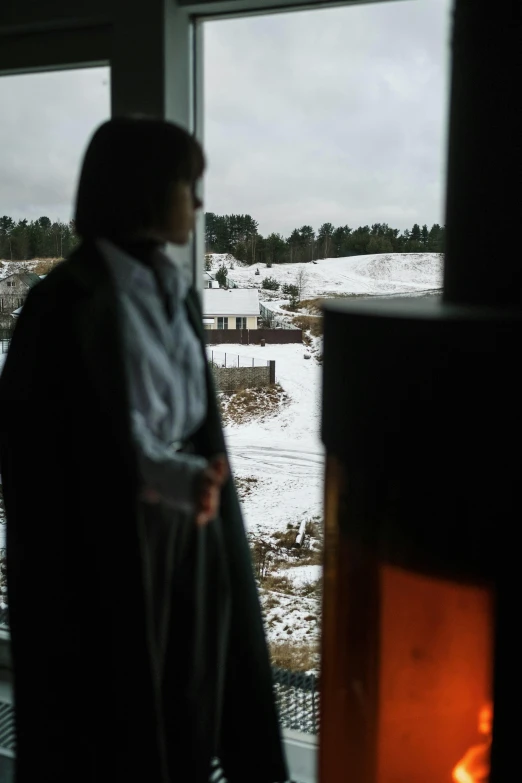 a person standing in front of a window with snow on it