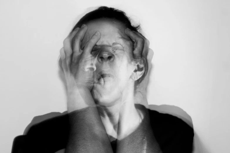 black and white image of a woman covering her eyes with hands