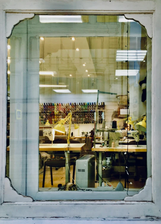 the reflection of two people working in a store window