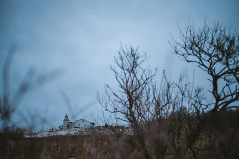 an overcast sky with an old farmhouse in the background