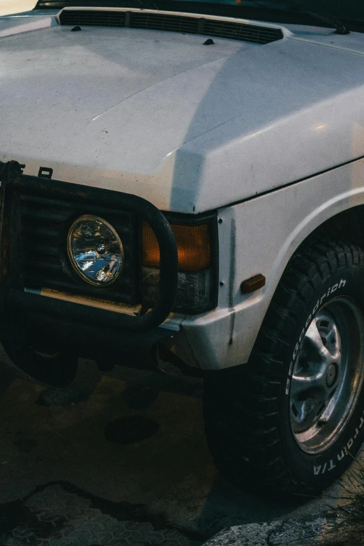 the front of a white truck with an emblem