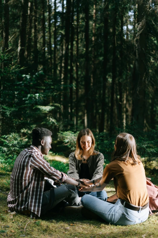 a group of friends having a picnic in the woods