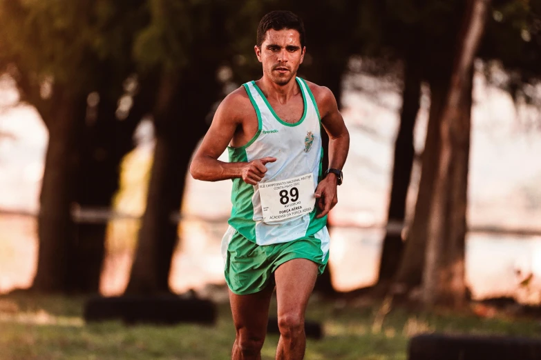 a man with a serious look on his face as he runs the race in a grassy area