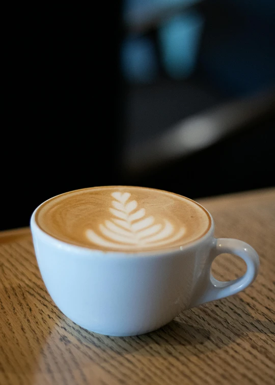 a cup of cappuccino that is on a table