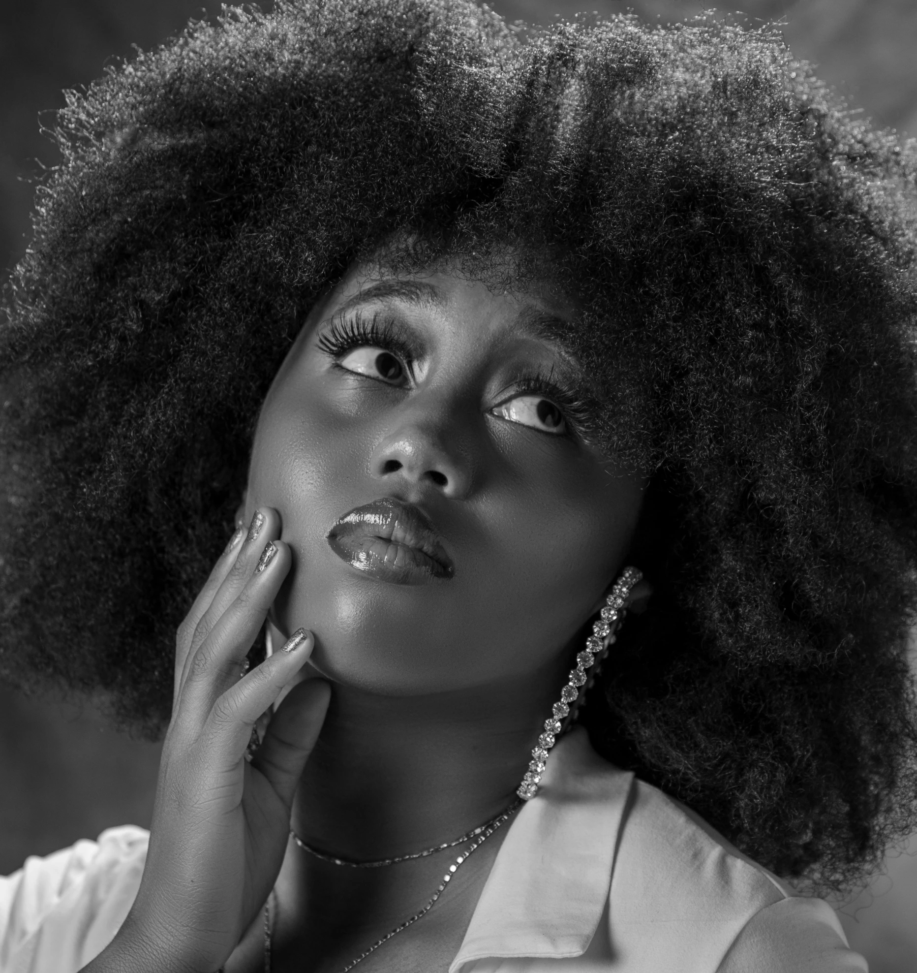 a black woman with an afro looking up to her left