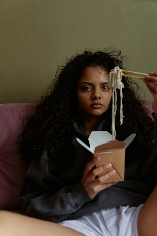 an image of a woman that is eating noodles