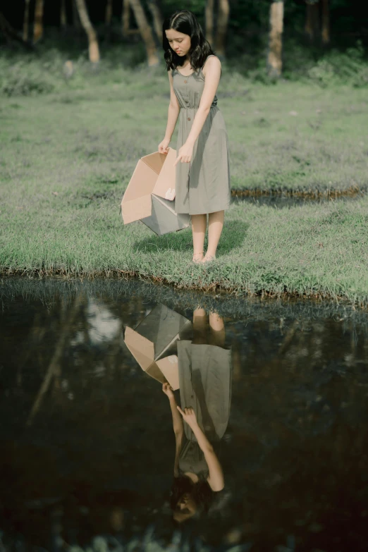 a woman with a bag standing on the shore by water