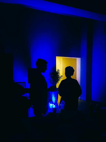 two people standing near each other in the dark