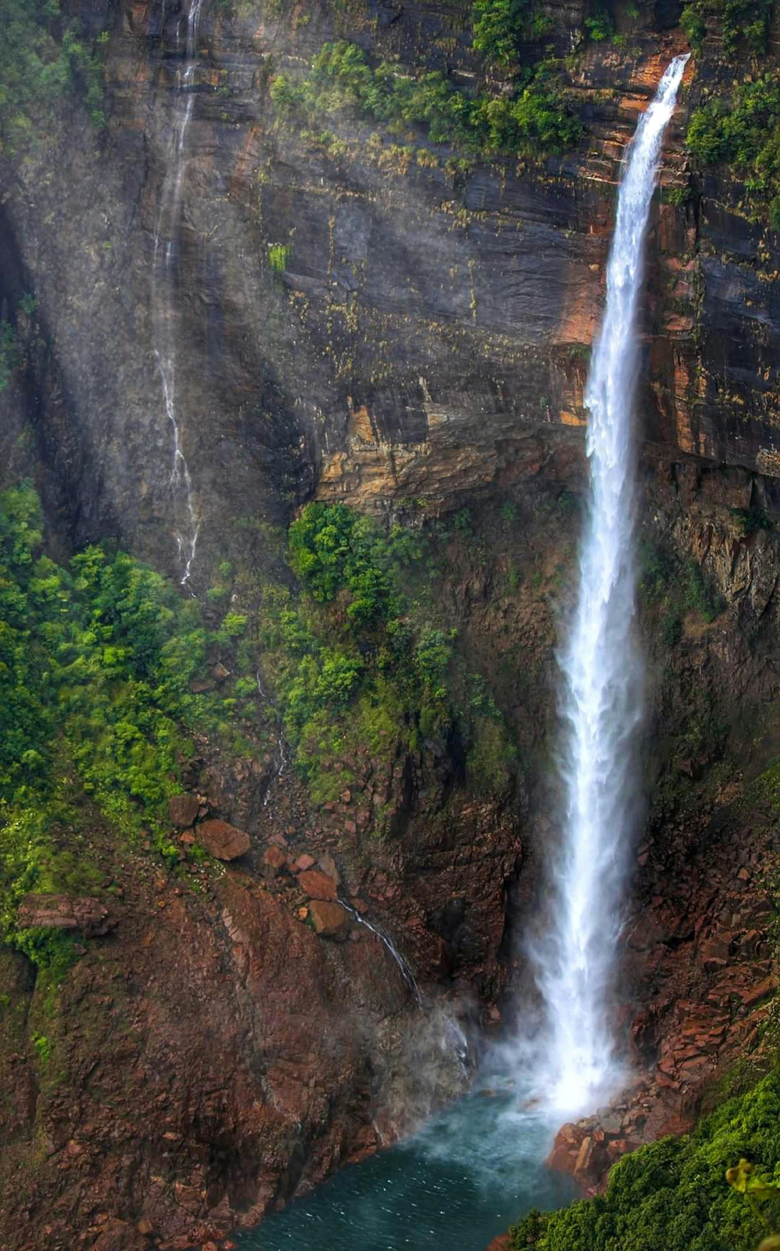 a waterfall with the sun shining in and above