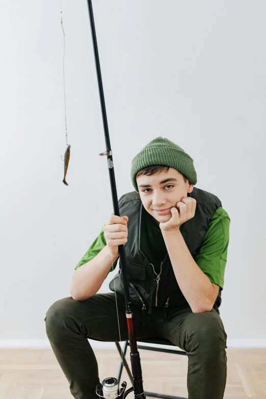 a man sits on the floor holding a fish