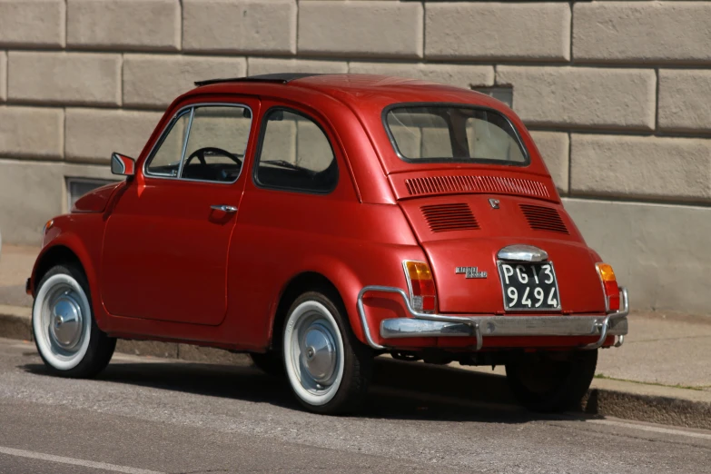 an old red car parked in front of a building