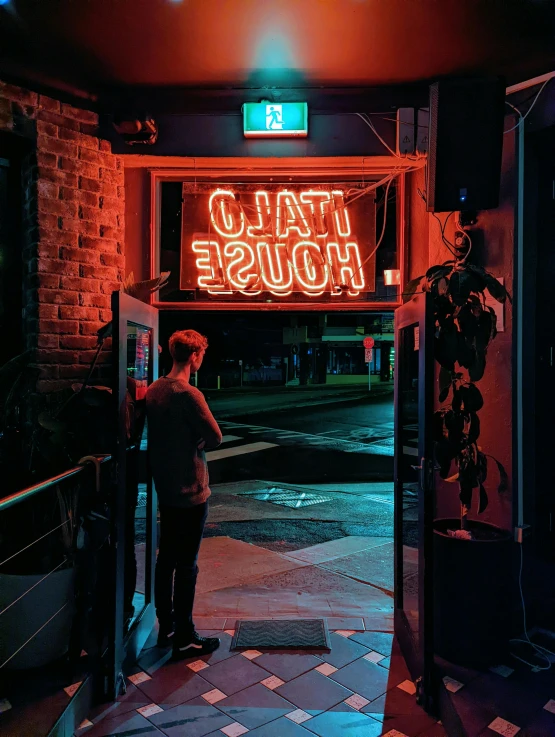 a person standing outside of a building that reads talo house