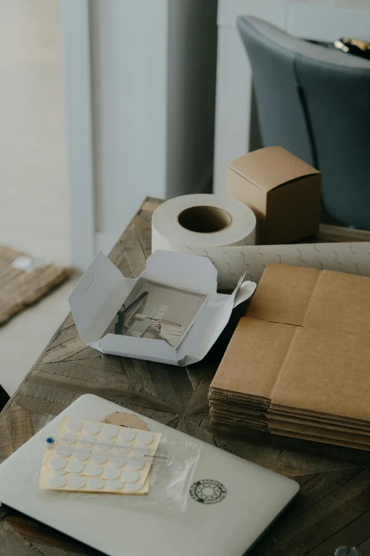 several books, papers and a toilet paper sit on a table