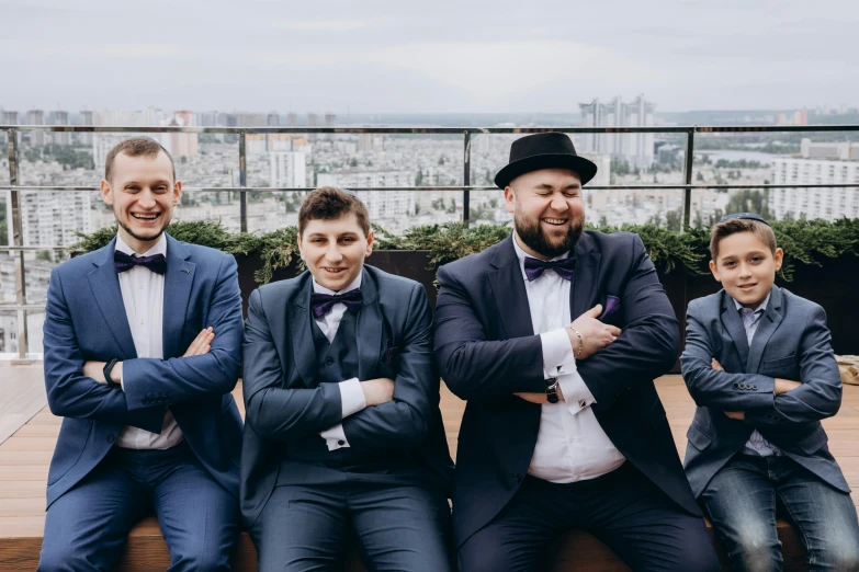 three people in suits posing for the camera with their arms crossed