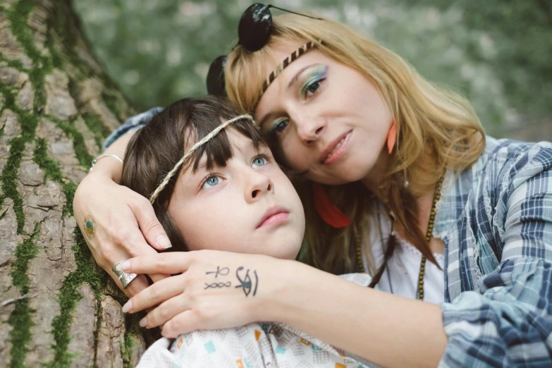 a woman leans her head on the shoulder of a child