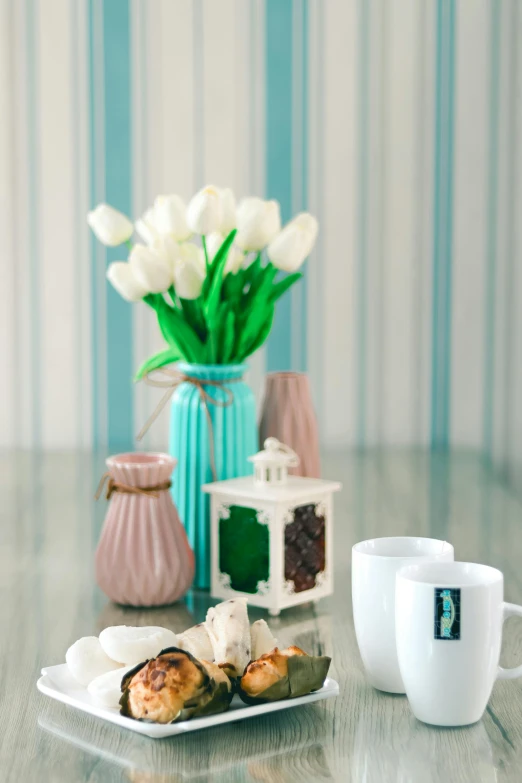 a plate of food on a table with a vase of flowers