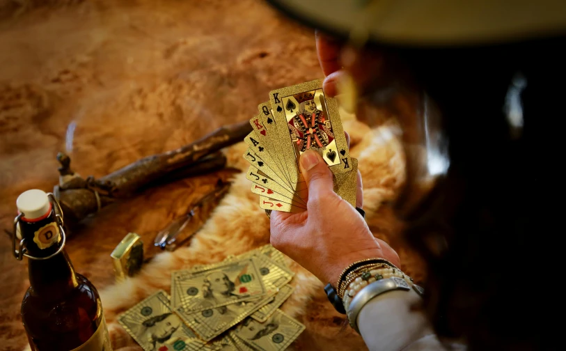 a man holding out some cards with gold paper