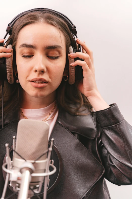 a woman in headphones listening to a microphone