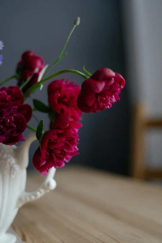 a vase with a bunch of pink flowers on the table