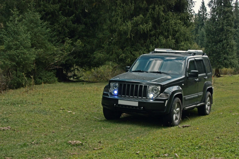 a green jeep with a light on it is parked in the grass