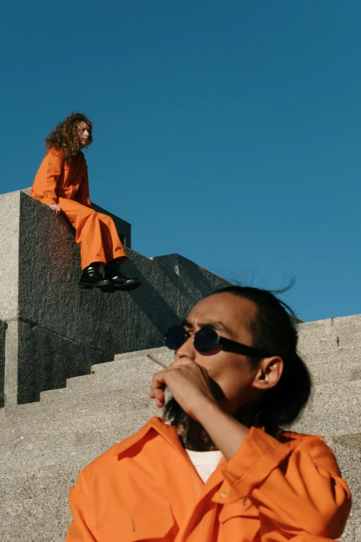 a man in orange clothes is sitting on stairs