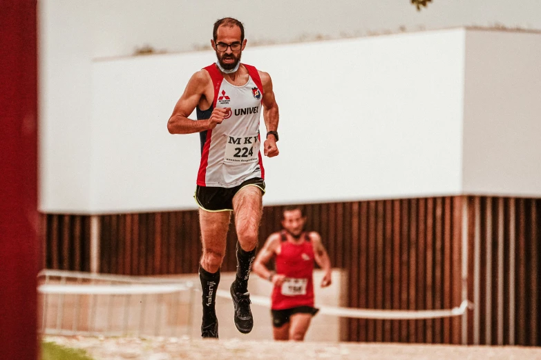 a man in black shorts and shorts runs past a building