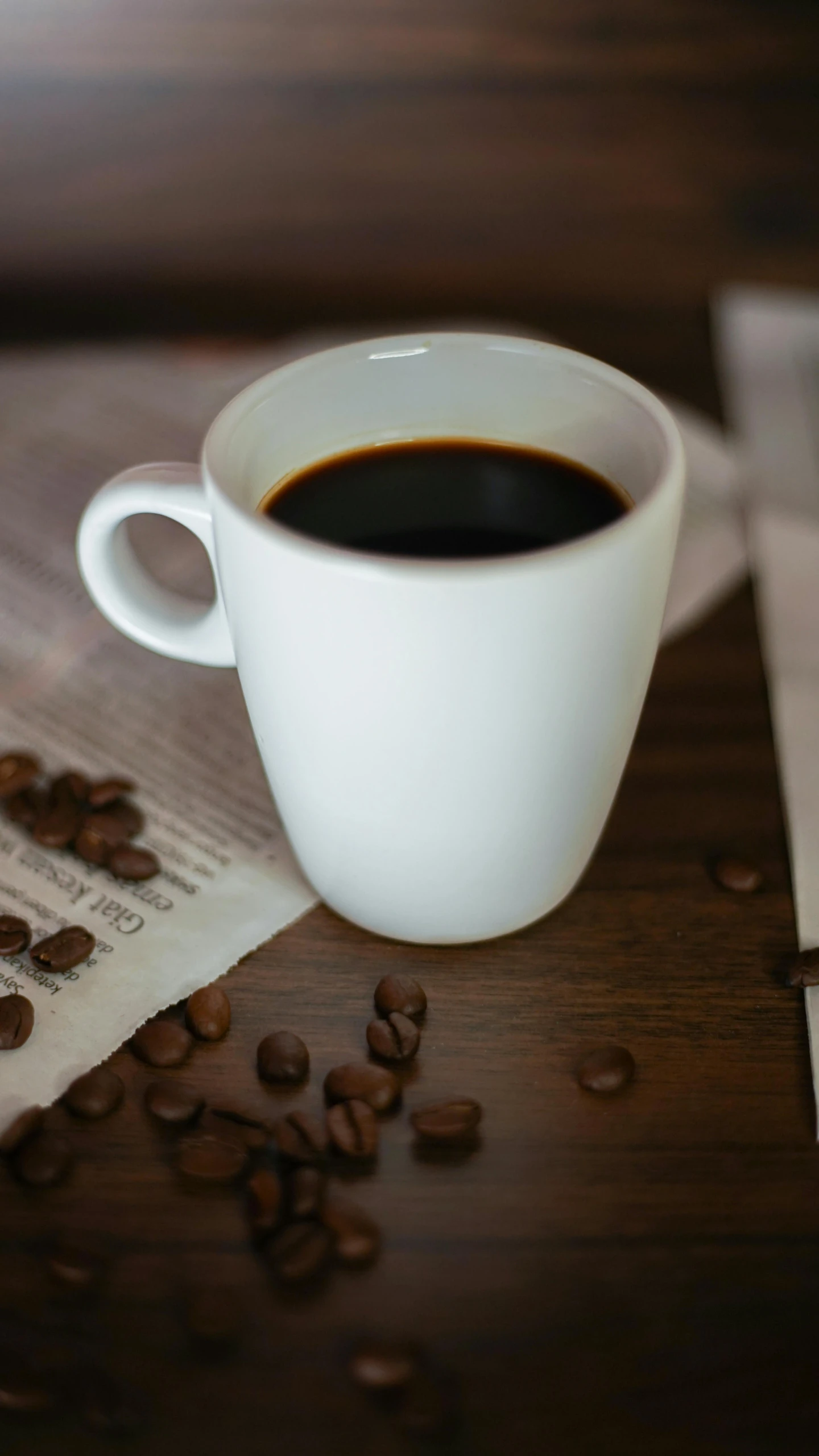 a coffee cup with coffee beans beside it