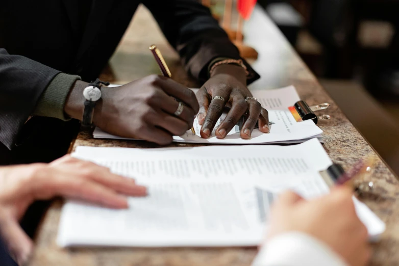 people sitting at a table doing paperwork