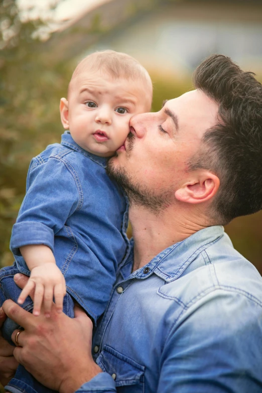 man kissing his baby in the face as they cuddle