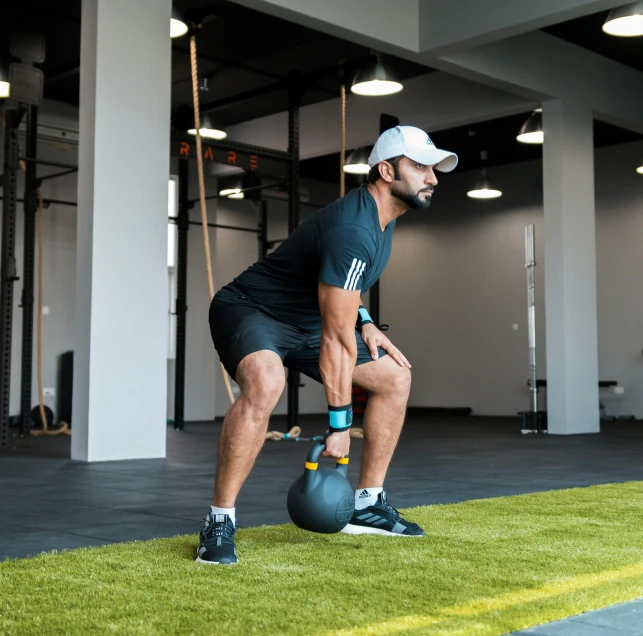 a man doing squats with an exercise ball on the ground