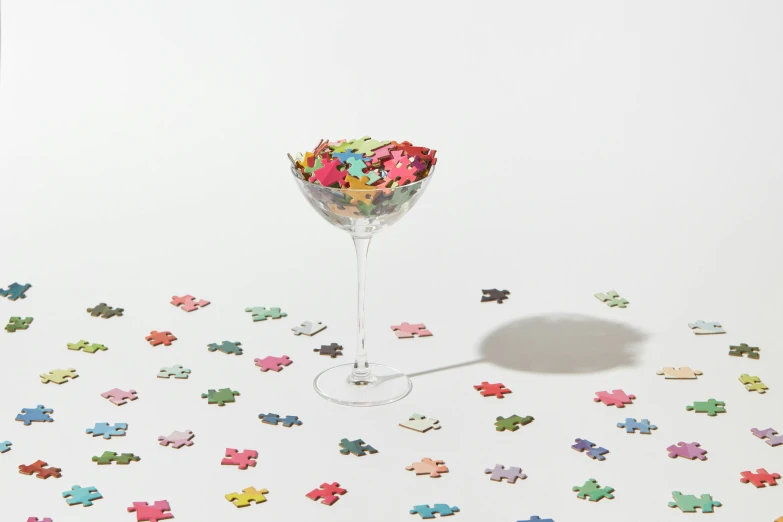 a glass filled with lots of different colored pieces of puzzles