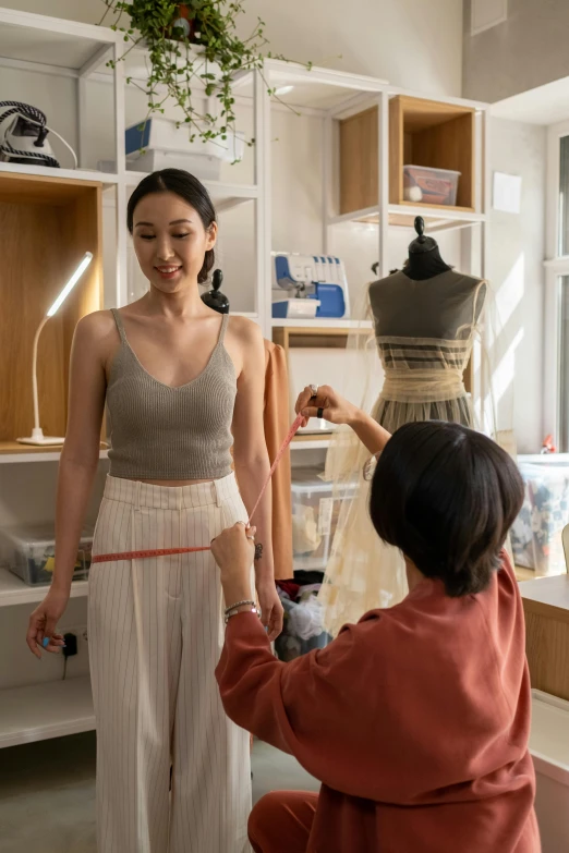 a young woman measuring a piece of clothing