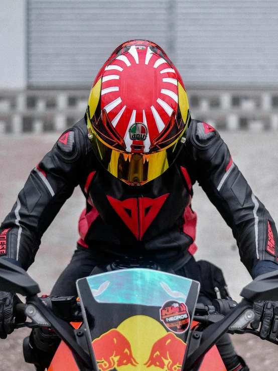 a person in helmet and leather outfit sitting on an orange dirt bike