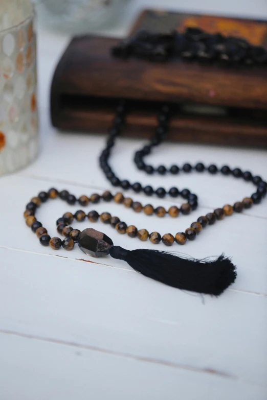 beads on a wooden rosary next to glass cups