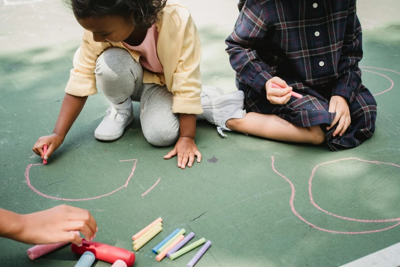 two s are drawing letters on a chalk board