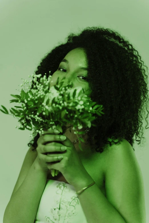 a woman holds a bush of green plants