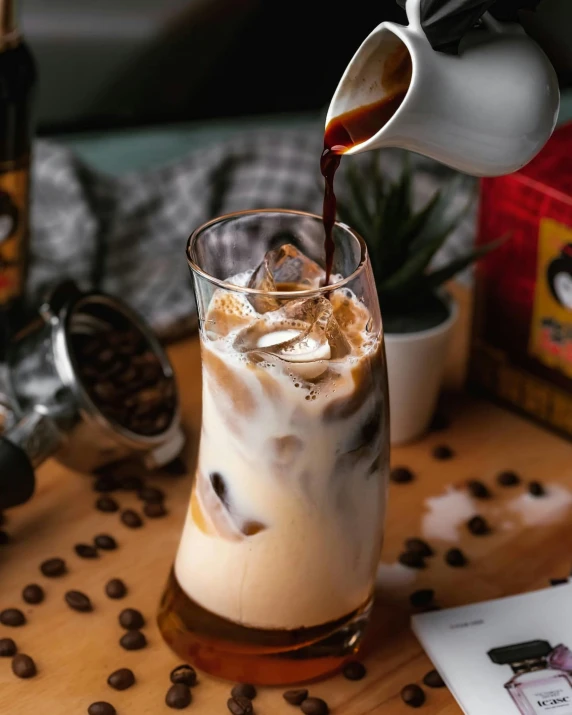 a pitcher pouring coffee into a cup of coffee